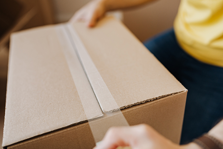 a person taping a box 